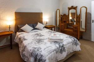 a bedroom with a large bed with towels on it at 273 Jan Van Riebeeck in Oudtshoorn