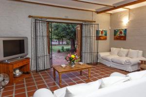 a living room with a couch and a tv at 273 Jan Van Riebeeck in Oudtshoorn
