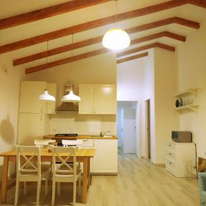 cocina con mesa y sillas en una habitación en Oca Bianca, en Pescia Romana