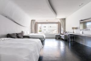 ein Hotelzimmer mit zwei Betten und einer Couch in der Unterkunft Modena B&B in Taitung