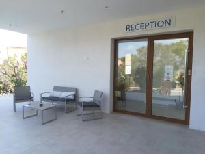 a waiting room with chairs and a door with a registration sign at Apartamentos Villa Primera in Cala Figuera