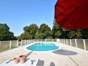 ブルボン・ランシーにあるVintage Mansion in Saint Aubin sur Loire with Poolの赤い傘が置かれたパティオのスイミングプール