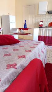 - un lit rouge et blanc dans une chambre avec cuisine dans l'établissement Monolocale Rosina, à Trapani