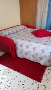 - un lit rouge et blanc avec une couette rouge et blanche dans l'établissement Monolocale Rosina, à Trapani