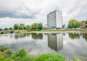 コウォブジェクにあるSenlux Apartmentsの大水の前の大きな建物