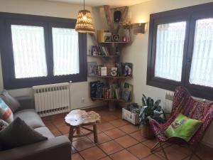 Hostal Rural Sant Climent في تاوول: غرفة معيشة مع أريكة وكراسي ونوافذ