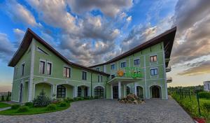 a large building with a cloudy sky in the background at Magus Hotel in Baia Mare