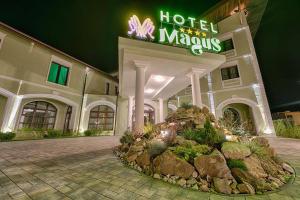 un hotel con un cartel frente a un edificio en Magus Hotel en Baia Mare