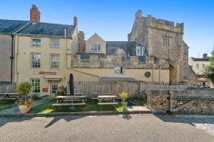 uma casa com uma mesa de piquenique em frente em The Ancient Gatehouse & Rugantino Restaurant em Wells