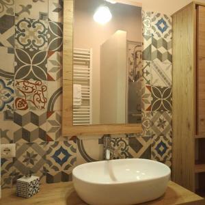 een badkamer met een witte wastafel en een spiegel bij Oca Bianca in Pescia Romana