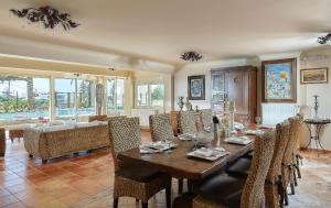 a dining room with a wooden table and chairs at Villa Living E-motion in Gournes