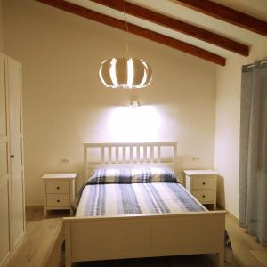 een slaapkamer met een bed en een kroonluchter bij Oca Bianca in Pescia Romana