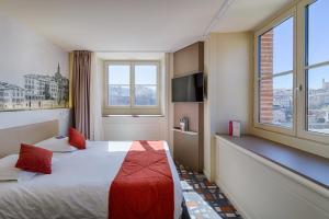 um quarto de hotel com uma cama e duas janelas em Mercure Albi Bastides em Albi