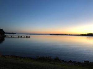 a view of a lake with a dock in the water at The Boat House in Strahan