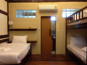 a room with two beds and a hallway with a door at Treasure Inn Khaoyai in Mu Si