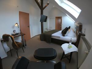 a bedroom with a bed with a cat laying on a pillow at Hotel Landgasthaus Schäferhof in Alsfeld