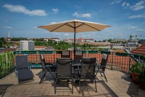 a table and chairs with an umbrella on a balcony at Penthouse with Free PARKING and Free BIKES, wellness 8 min walk in Budapest