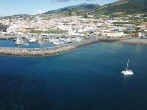 an aerial view of a harbor with a boat in the water at Vinha da Areia Beach Hotel in Vila Franca do Campo