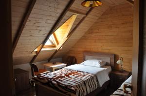 a bedroom with a bed in a wooden attic at Bujtina Gjana in Kukës