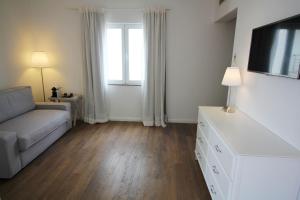 a living room with a couch and a tv at Vinha da Areia Beach Hotel in Vila Franca do Campo