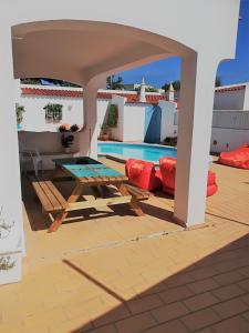 eine Terrasse mit einem Picknicktisch und einem Pool in der Unterkunft Villa Quica, heated pool in Albufeira