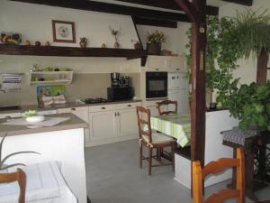 a kitchen with a table and chairs and a kitchen with a counter at Maison Confortable WI-FI Animaux oui in Marennes