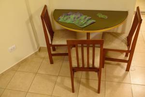 stół jadalny z 2 krzesłami i stół ze stołem w obiekcie AVEMAR Apart Hotel w mieście Posadas
