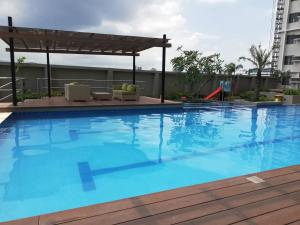 a large blue swimming pool with a pergola at Nica's Place Property Management Services at Horizons 101 Condominium in Cebu City