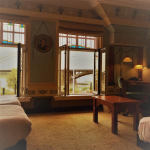 Hotel Courage Waalkade في نايميخن: غرفة نوم بسرير وطاولة ونوافذ