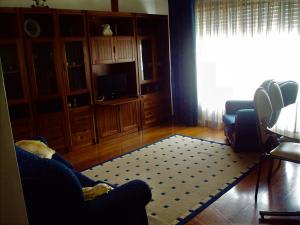 sala de estar con sofá y alfombra en Edificio Saul Fanha, en Nazaré