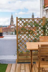 una panca di legno seduta sopra un ponte di legno di Santiago Center Rooms a Santiago de Compostela