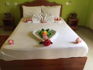 uma cama com lençóis brancos e flores em Sun & Earth Villa em Mont Choisy