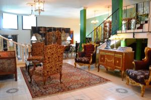 a living room with chairs and a staircase at Palacio Domain - Stylish European Luxury Boutique Hotel in Safed