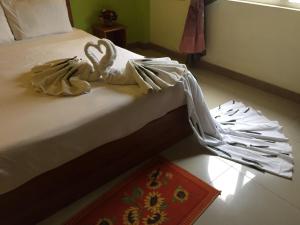 uma cama com lençóis brancos e toalhas em Sun & Earth Villa em Mont Choisy