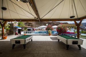 dwa stoły do ping ponga pod dużym parasolem w obiekcie Servatur Terrazamar Sun Suite w mieście Puerto Rico de Gran Canaria