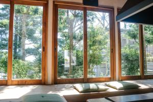 a room with windows and a bed with pillows at Irori Guest House Tenmaku in Hakone