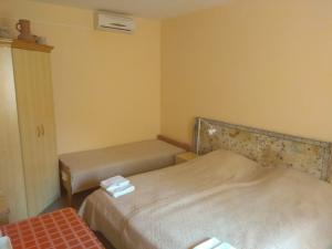 a small room with two beds and a window at Hubertus Panzió in Csongrád
