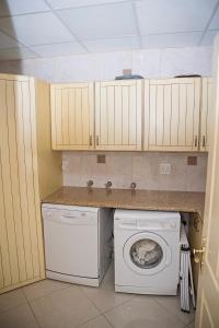 een keuken met een wasmachine en een wasmachine bij RONDEVOUX 64 in Margate