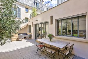 d'une terrasse avec une table et des chaises en bois. dans l'établissement Le clos de l'olivier, à Paris