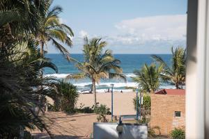 vistas a una playa con palmeras y al océano en RONDEVOUX 64 en Margate