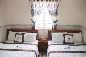 1 dormitorio con 2 camas y ventana en Triệu Hoàng Hotel, en Quy Nhon