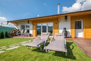 a house with two chairs on the yard at Villa ADELHEIDE - Spa & BBQ in Beli Iskar