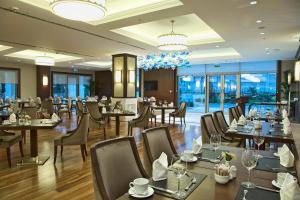 a restaurant with tables and chairs and windows at Rotta Hotel Istanbul in Istanbul