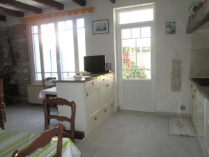 een keuken met een bureau, een tv en een raam bij Maison Confortable WI-FI Animaux oui in Marennes