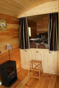 a bedroom with a bed and a stove in a cabin at les roulottes de dilou Cerise in Matha