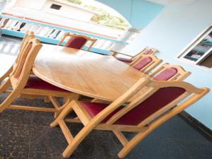 four chairs around a wooden table in a room at Elizz guest house in Accra