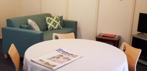 a living room with a table and a green couch at Park Avenue Holiday Units in Albany