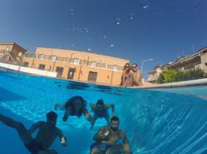 um grupo de pessoas a nadar numa piscina em Agathae Hotel & Residence em Scoglitti