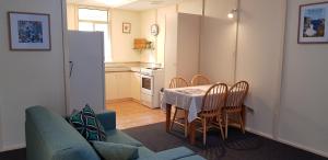 a kitchen with a table, chairs and a refrigerator at Park Avenue Holiday Units in Albany