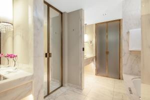 a bathroom with a shower and a sink and a tub at Park Hyatt Vienna in Vienna